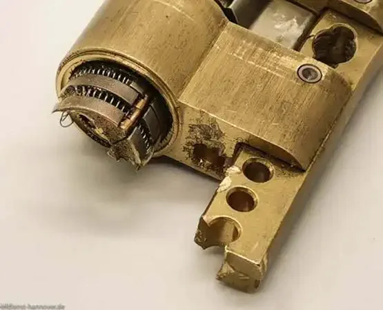 Beschädigtes ausgebautes Schließbauteil mit freiliegender Mechanik