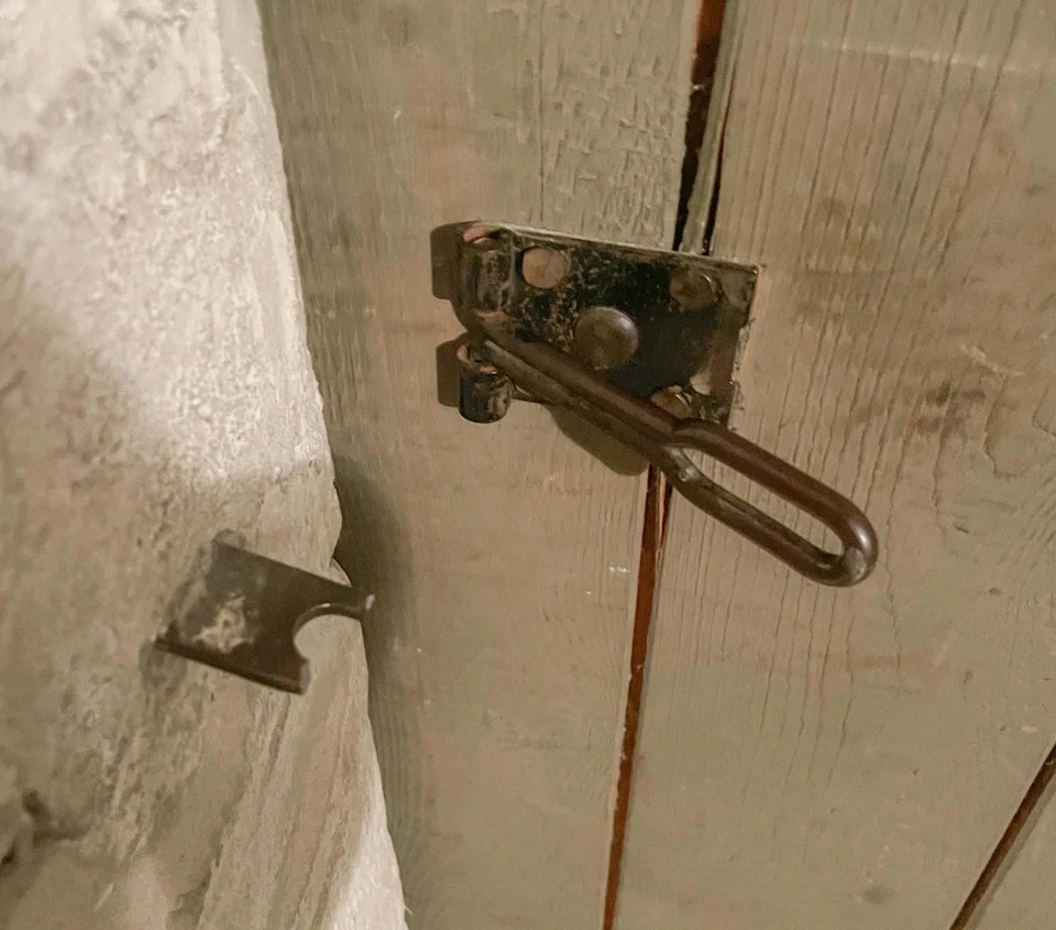 Beschädigte Befestigung einer Kellersicherung an einer Holztür